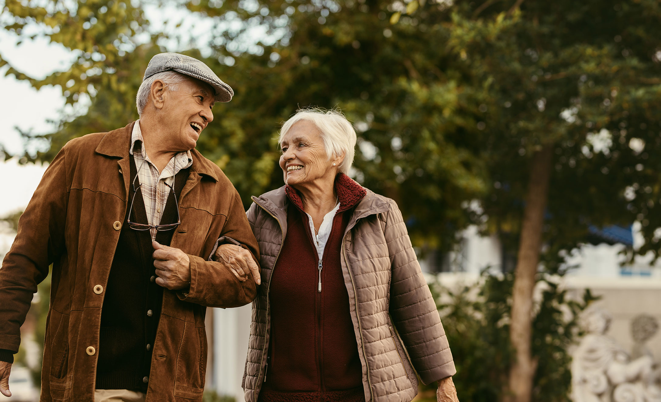 Older couple walks arm-and-arm outside